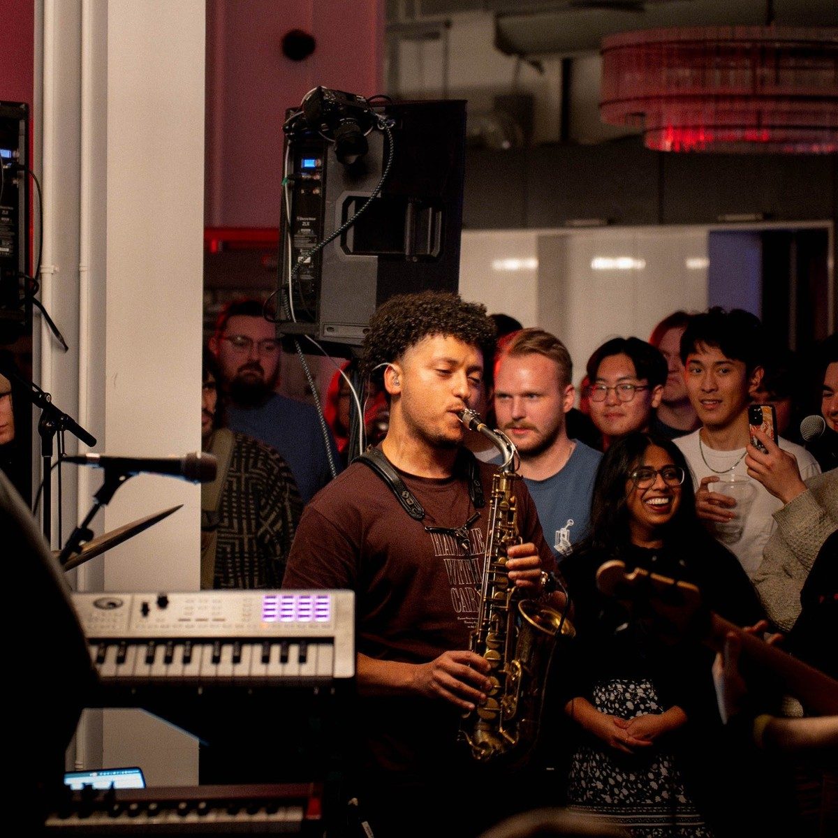 A saxophonist playing to a crowd during live music at a Den 1880 event