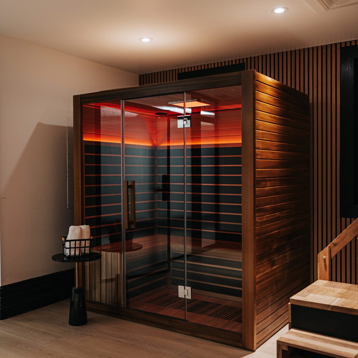 The cedar infrared sauna in the recovery suite at Den 1880, lit from within