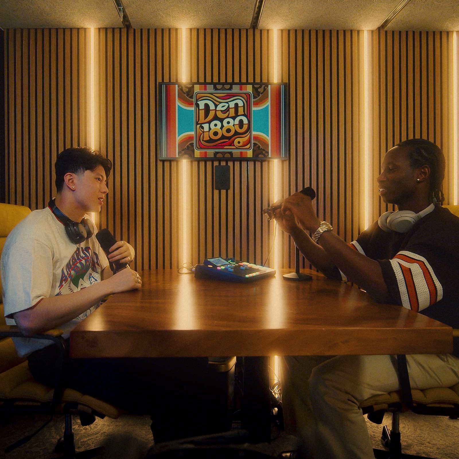 Two people recording an episode at the table in The Vault podcast studio at Den 1880