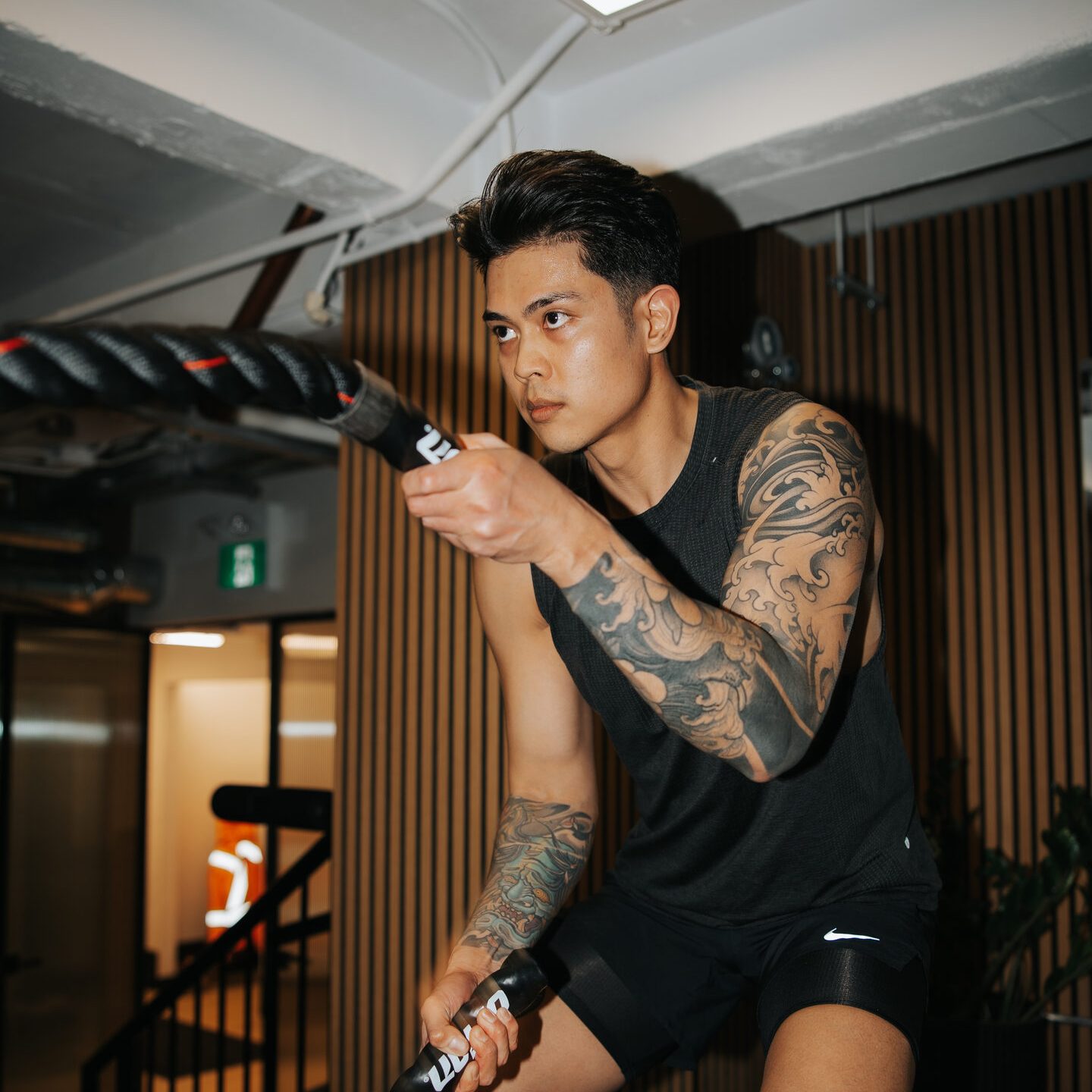 A member training with battle ropes in the functional zone of the Performance Club gym