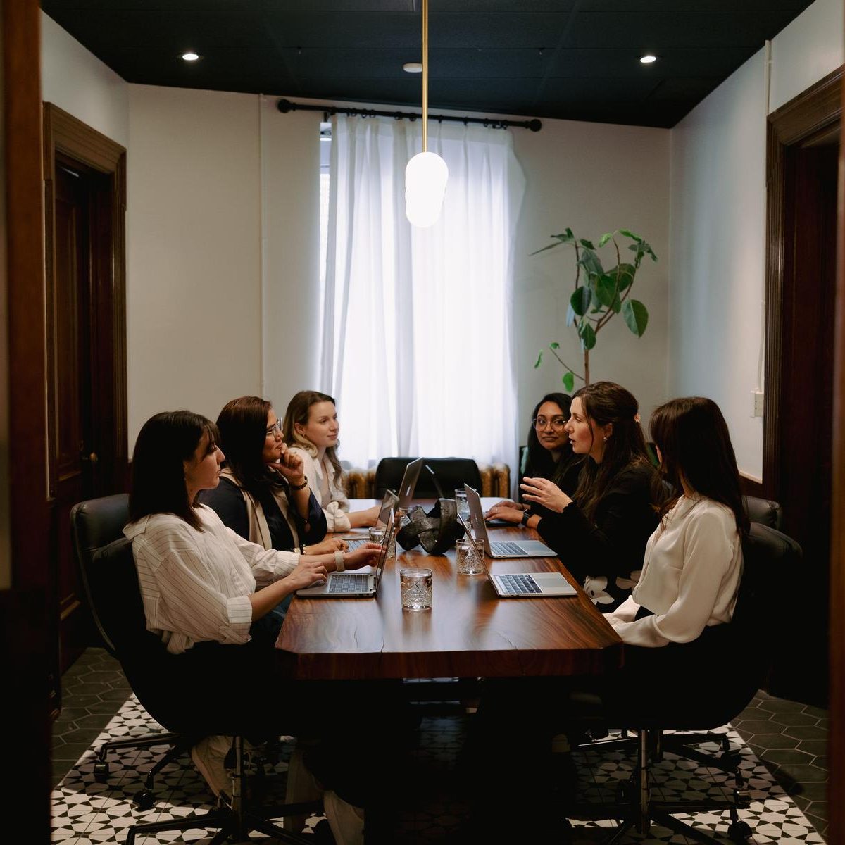 Colleagues working around the boardroom table in a private meeting room at Den 1880
