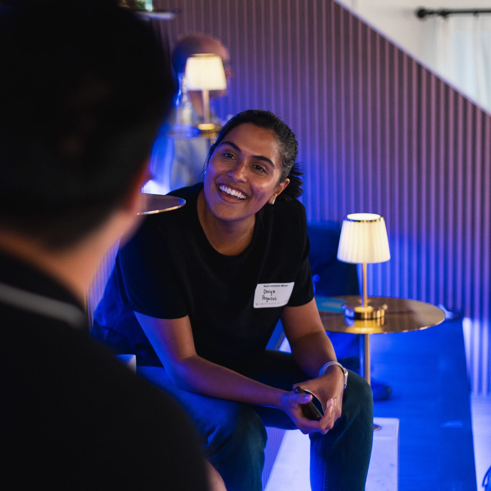 A guest laughing mid-conversation at an evening reception at Den 1880 in Uptown Waterloo