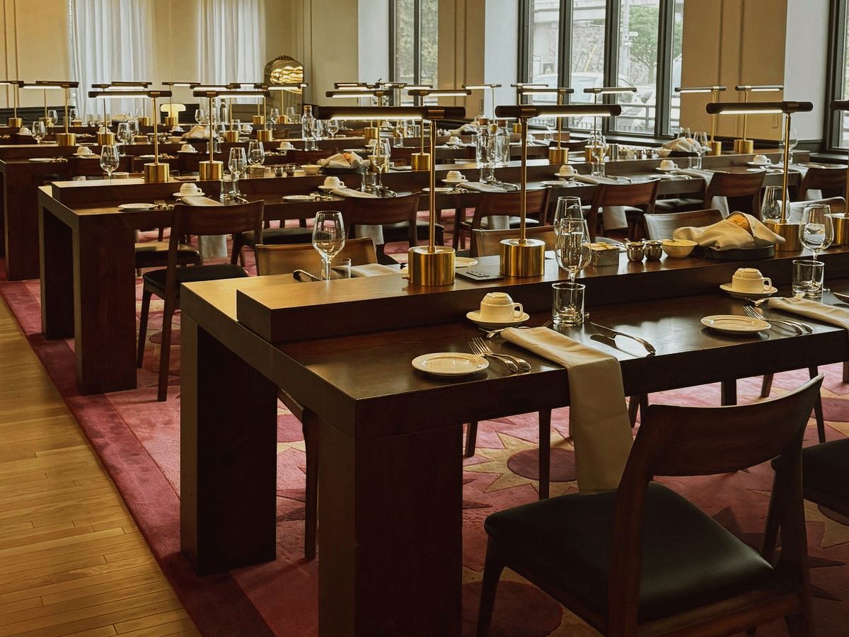 Long harvest tables set for dinner in the Library at Den 1880