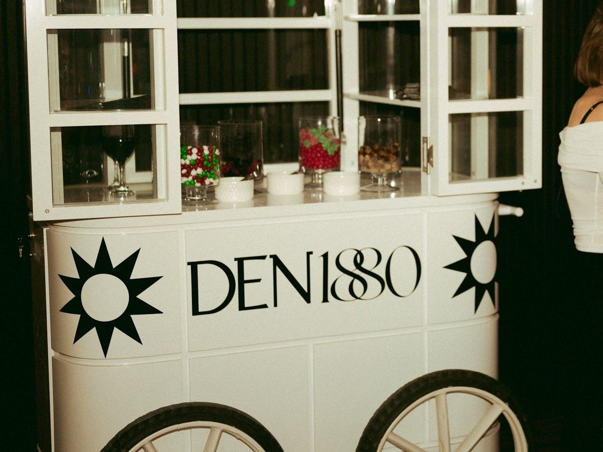 A white mobile bar cart at a Den 1880 event