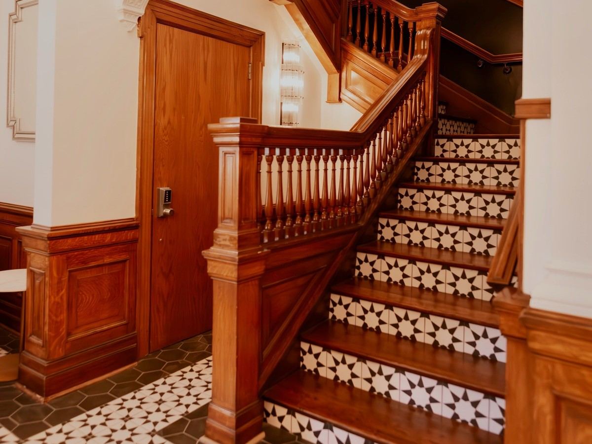 The original wooden staircase and mosaic tile floor at Den 1880