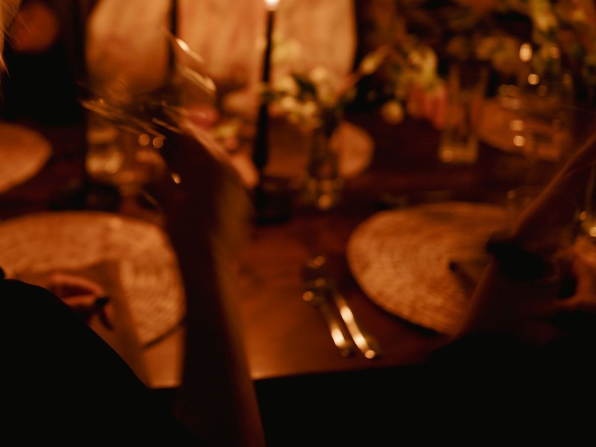 Candlelight across a dinner table at Den 1880