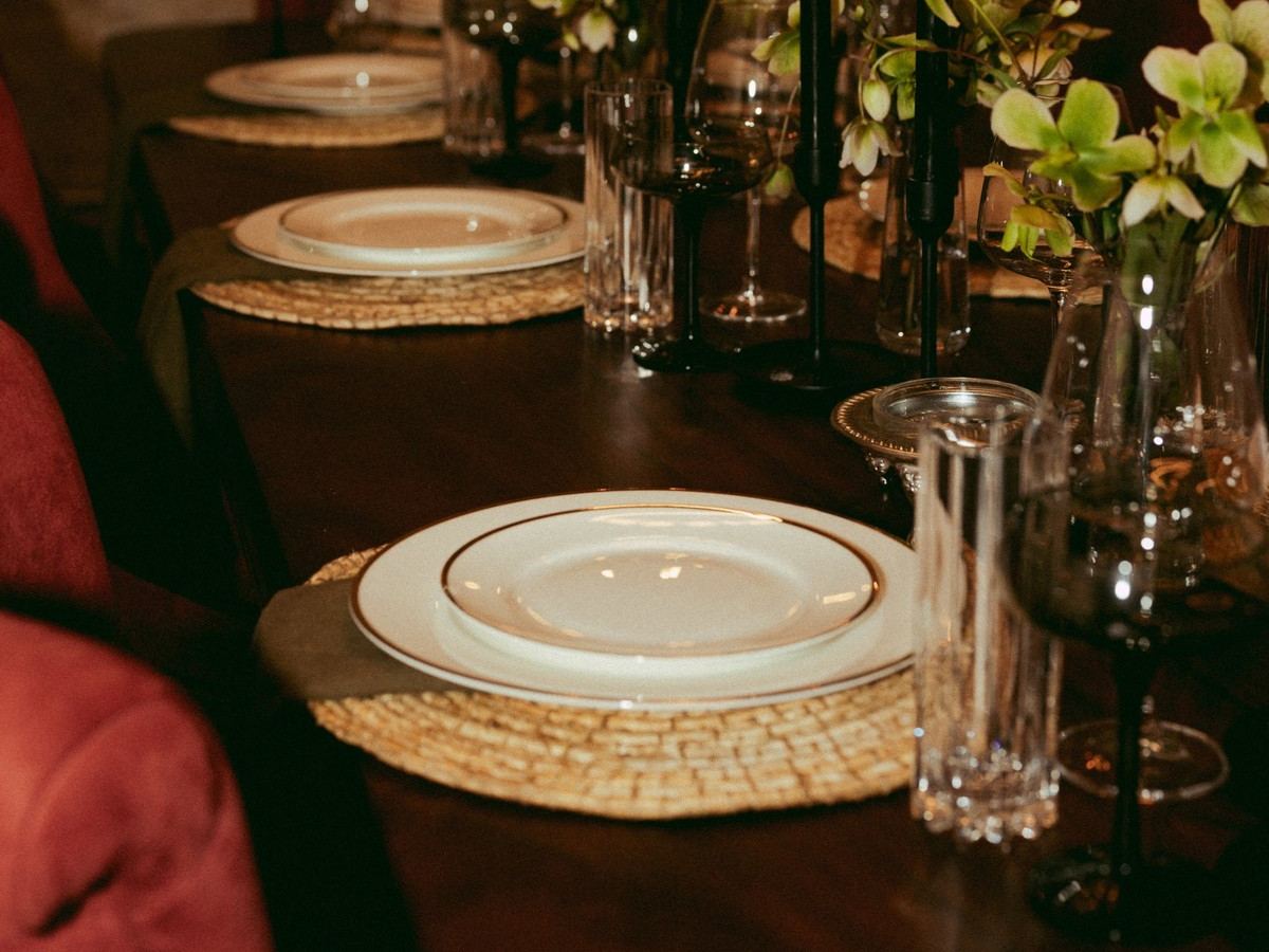 A tablescape at Den 1880 with black taper candles and greenery