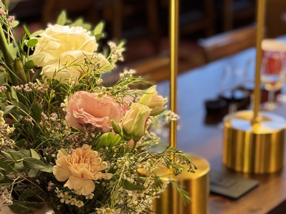 Flowers and gold candle holders on the bar at Den 1880