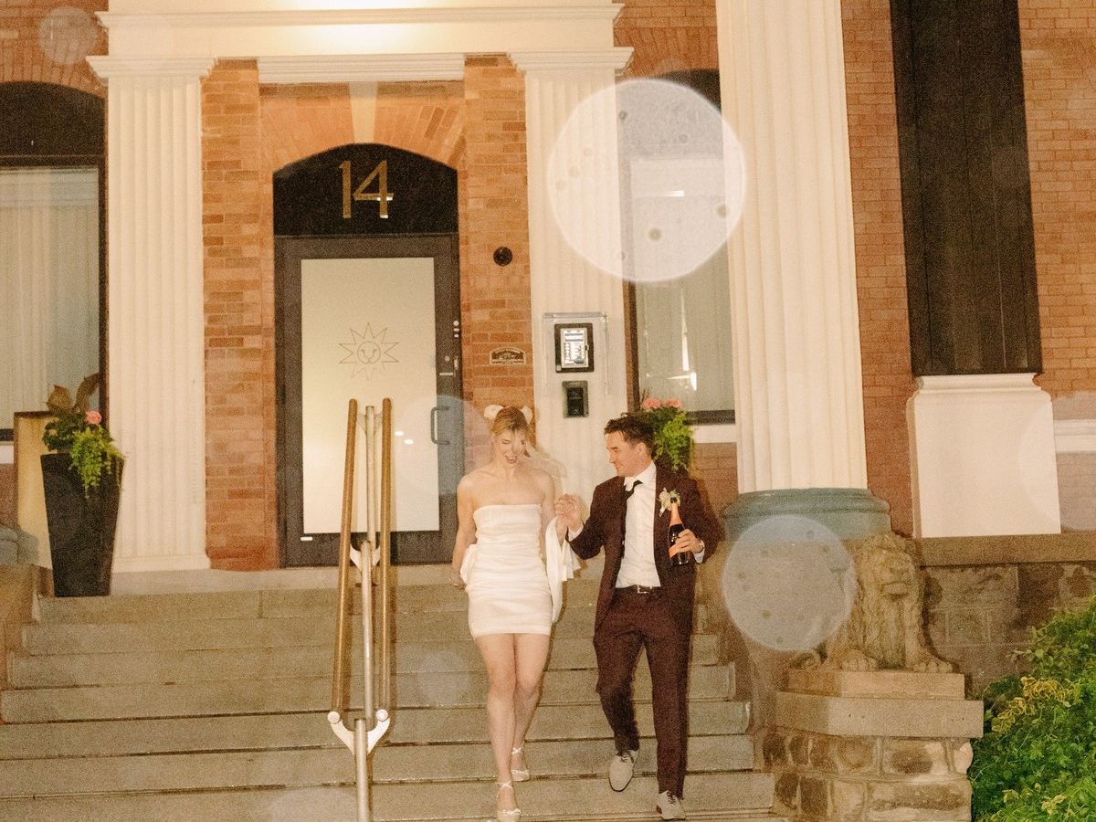 A couple walking down the front steps of Den 1880