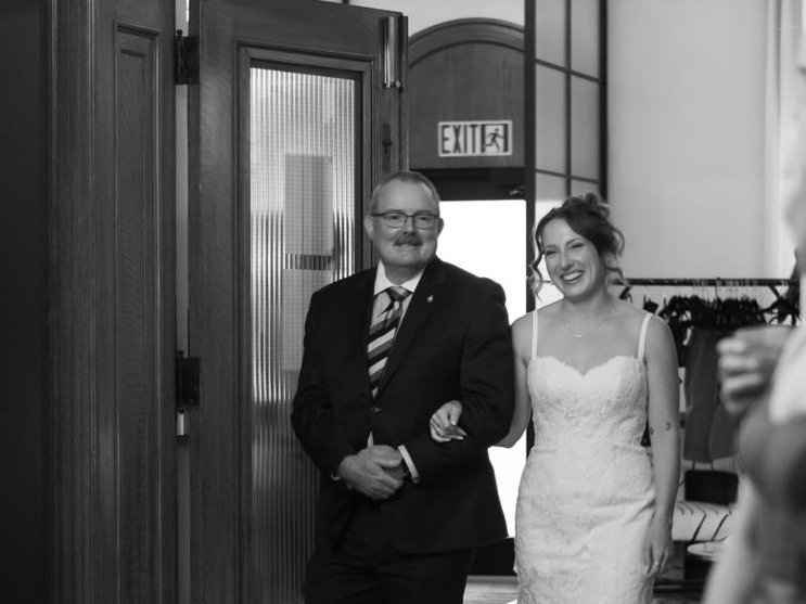 A bride arriving with her father to applauding bridesmaids at Den 1880