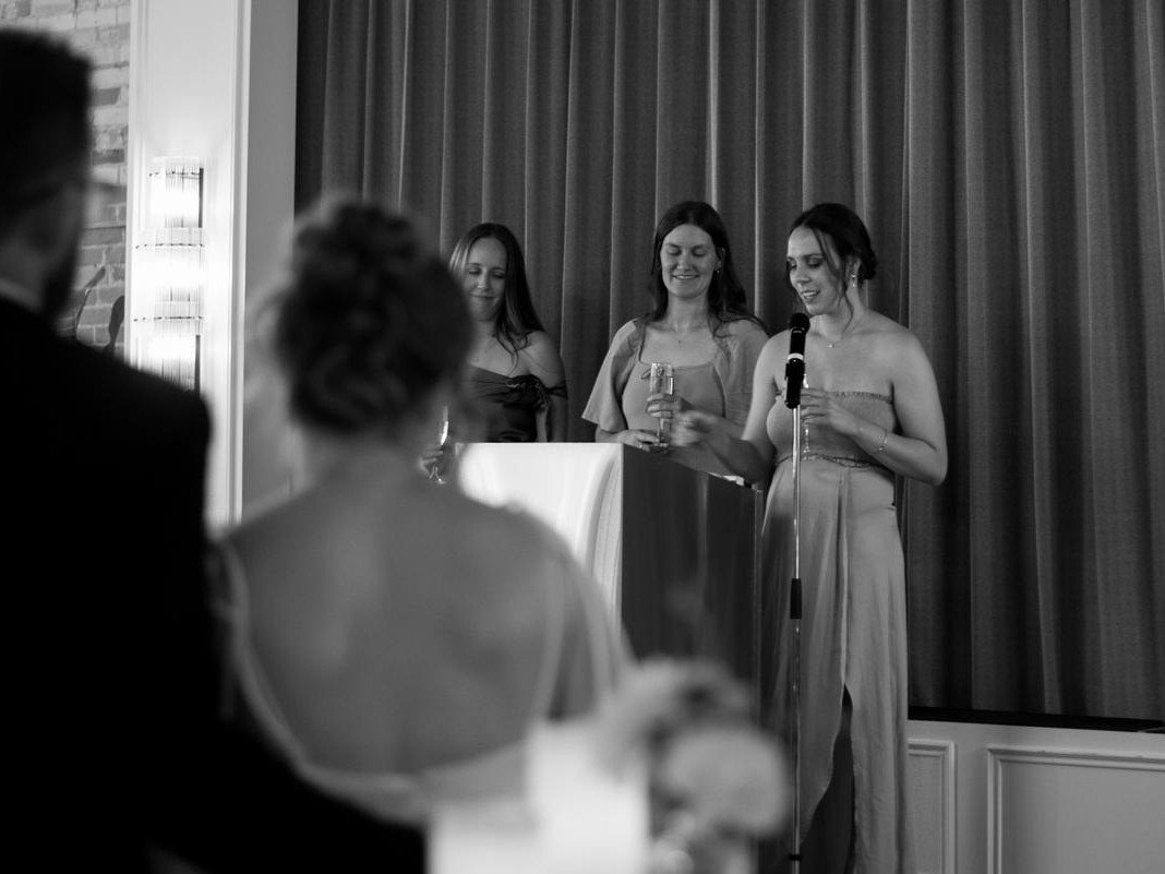 The wedding party giving a toast on stage at Den 1880