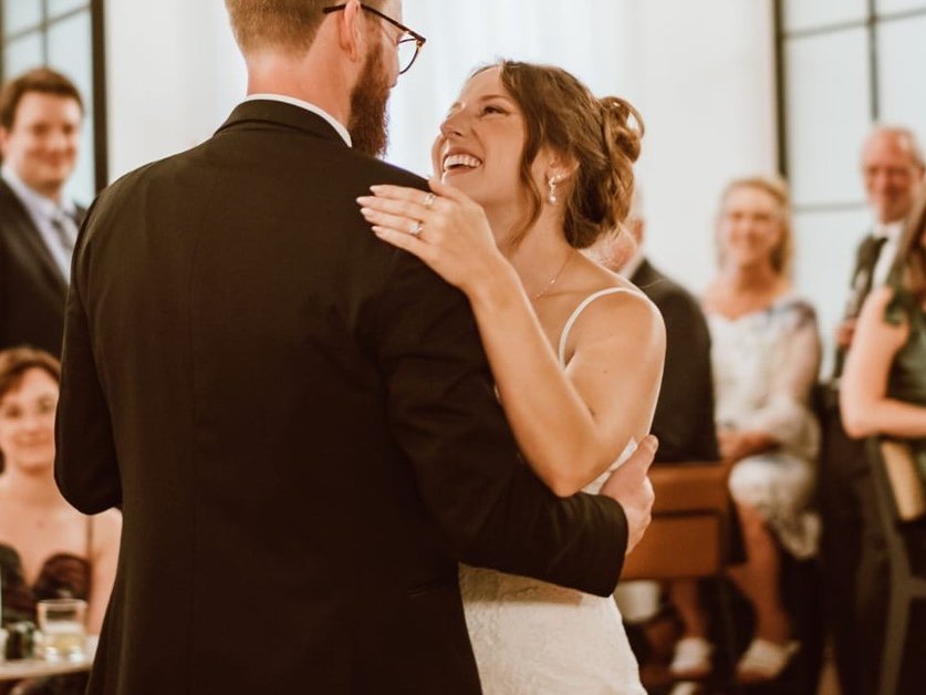 A bride and groom laughing during their first dance at Den 1880