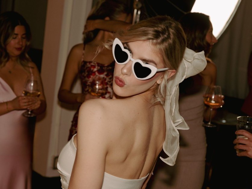 A bride in heart-shaped sunglasses at her Den 1880 wedding