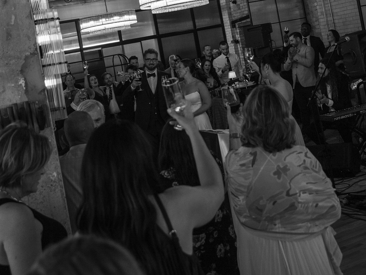 Wedding guests raising a toast at a Den 1880 reception